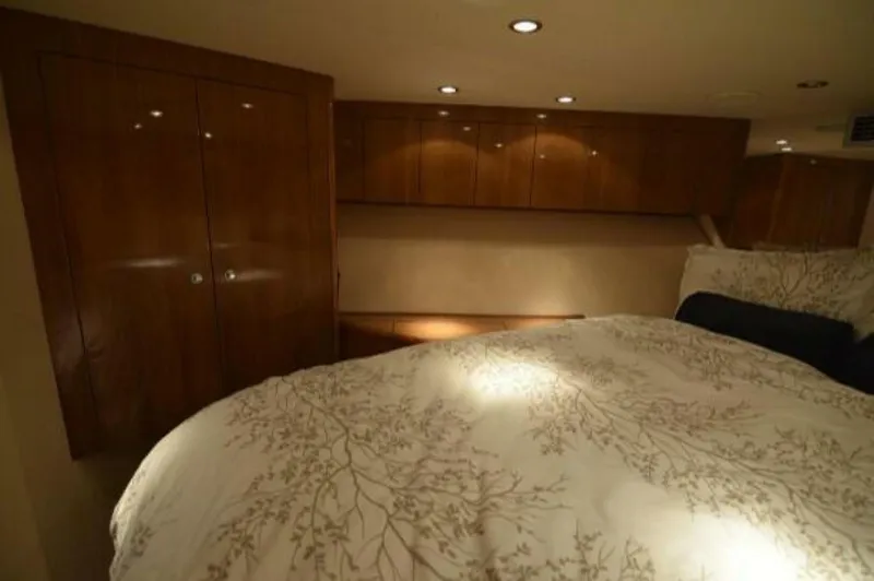 Burnin Daylight Yacht Photos Pics Luxurious bedroom interior of 2006 Hatteras 50 Convertible yacht with elegant wood cabinetry.