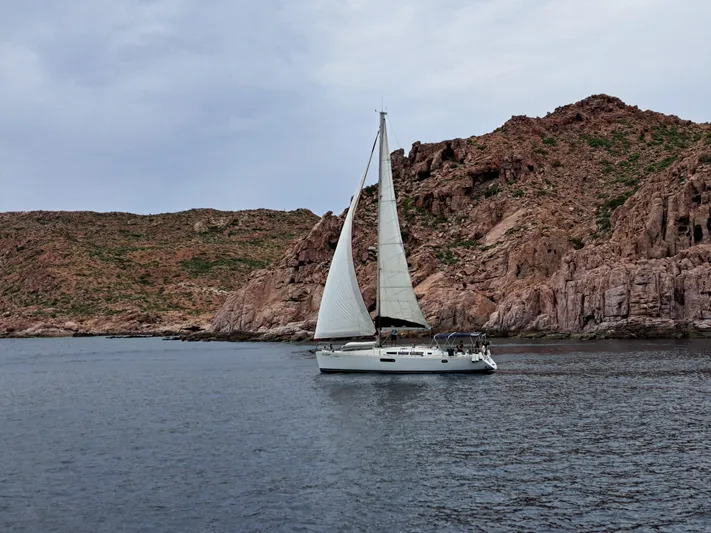  Yacht Photos Pics Sailboat Jeanneau Sun Odyssey 45, 2011, cruising near rocky coastline under cloudy sky.