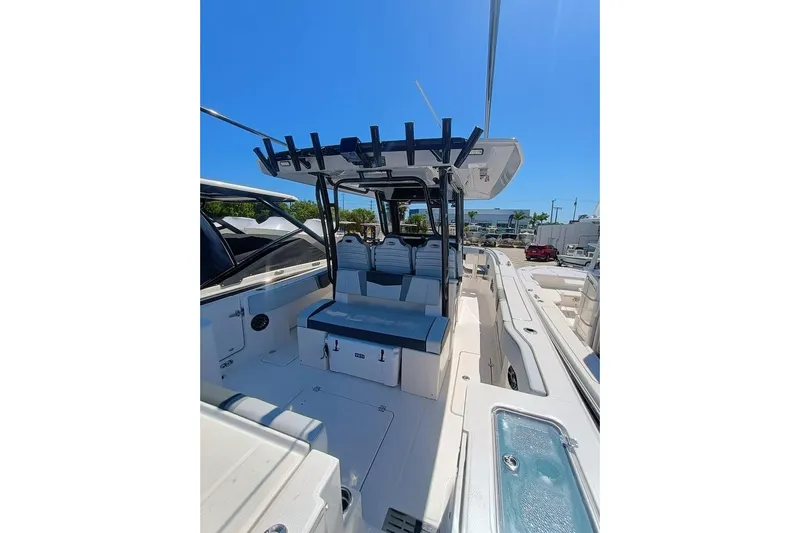 300-115 Yacht Photos Pics 2025 Robalo R300 Center Console boat interior with seating and storage, under clear blue sky.