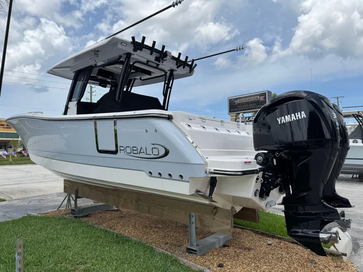 300-115 Yacht Photos Pics 2025 Robalo R300 Center Console boat with Yamaha engines on display outdoors.
