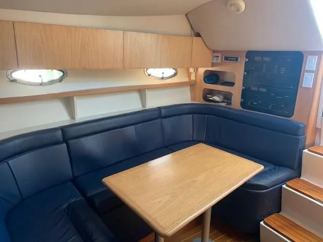 Mickadoo Yacht Photos Pics 2001 Tiara Yachts 3100 interior with blue seating and wooden table.