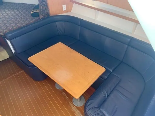 Mickadoo Yacht Photos Pics 2001 Tiara Yachts 3100 interior with blue leather seating and wooden table.