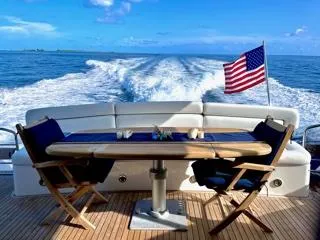 My Sirena Yacht Photos Pics Sunseeker Manhattan 70 yacht deck with ocean view, American flag, and seating area, 2008 model.