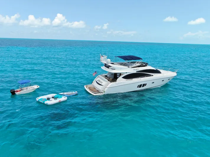 My Sirena Yacht Photos Pics Sunseeker Manhattan 70 yacht, 2008 model, anchored in clear blue ocean with inflatable boats nearby.