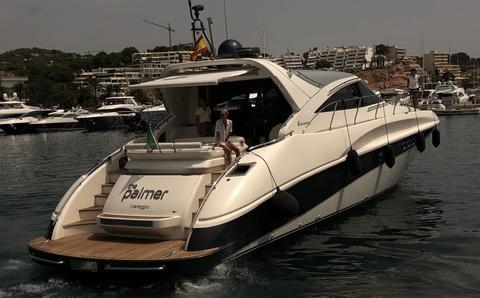 Luxury yacht AB 68, 2004 model, cruising in a marina with cityscape background.
