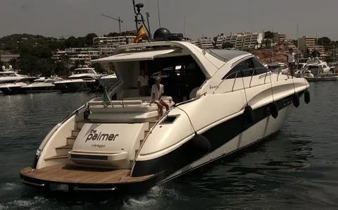 Luxury yacht AB 68, 2004 model, cruising in a marina with cityscape background.