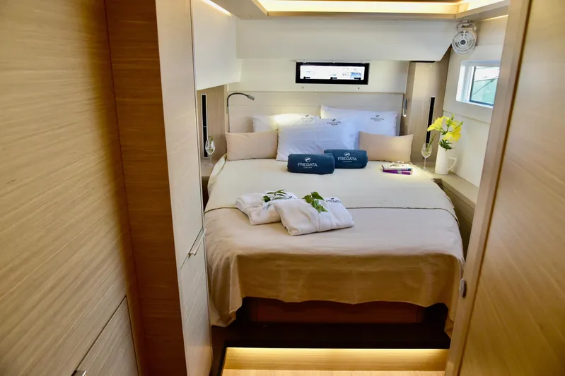 Fregata Lagoon Yacht Photos Pics Luxurious cabin interior of 2023 Lagoon 46 yacht with cozy bed and elegant decor.