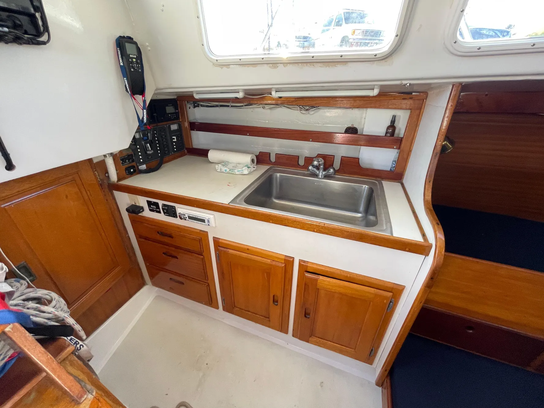 1964 CAL 40 sailboat interior with wooden cabinets and stainless steel sink.