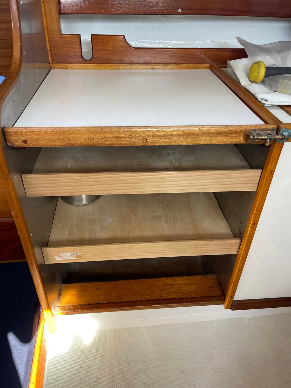 Wooden cabinet with open shelves inside a 1964 CAL 40 sailboat interior.