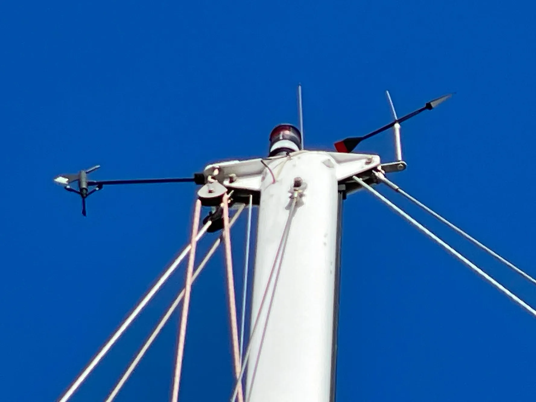 Mast top of 1964 CAL 40 sailboat against clear blue sky.
