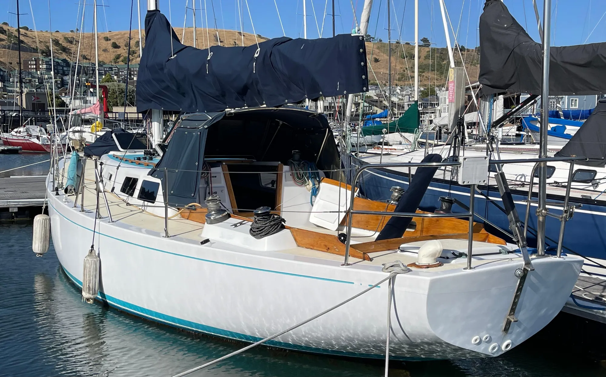 1964 CAL 40 sailboat docked in marina, featuring classic design and white hull.