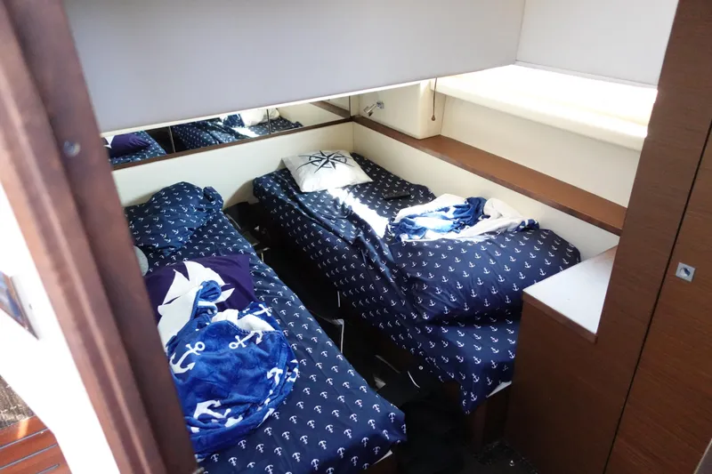  Yacht Photos Pics Cabin interior of 2012 Sea Ray 450 Sedan Bridge with twin beds and nautical-themed bedding.