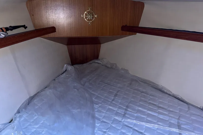 Nauti Cat Yacht Photos Pics Cozy cabin interior of 2005 Hunter 38 sailboat with wooden accents and bedding.