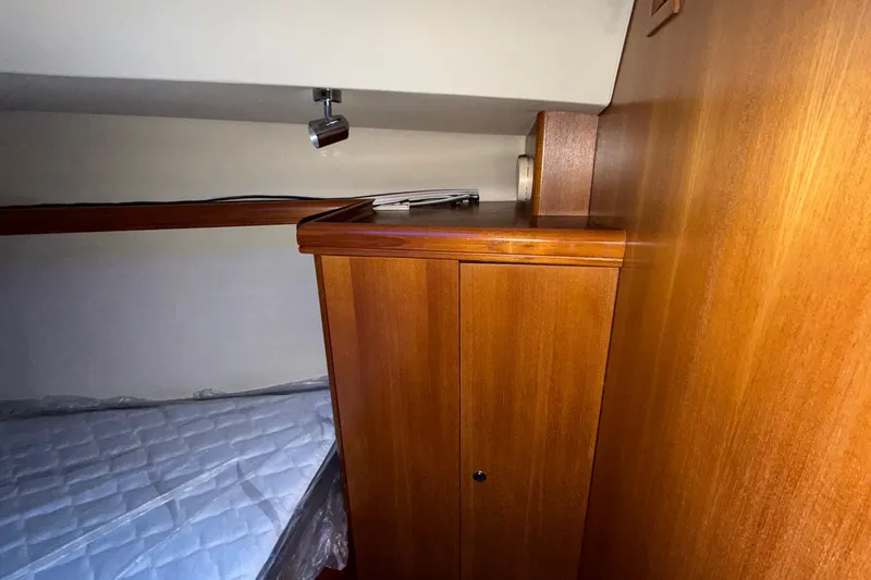 Nauti Cat Yacht Photos Pics Interior cabin of 2005 Hunter 38 sailboat with wooden cabinetry and bed.