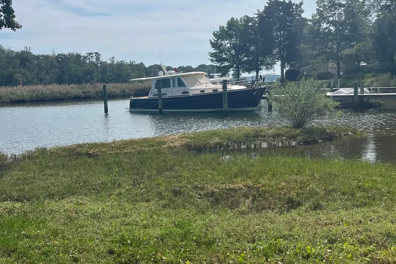 Sundog Yacht Photos Pics 2012 Sabre 42 Salon Express yacht docked in a serene, tree-lined waterway.