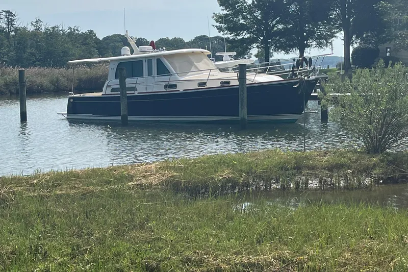 Sundog Yacht Photos Pics 2012 Sabre 42 Salon Express yacht docked in a serene, wooded marina setting.