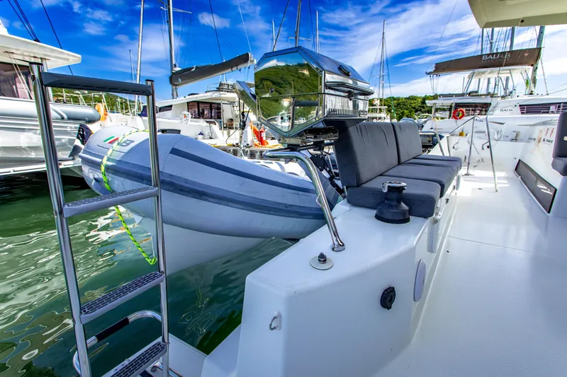 Bodhi Quest Yacht Photos Pics 2023 Fountaine Pajot Isla 40 catamaran with dinghy and outdoor seating in marina.