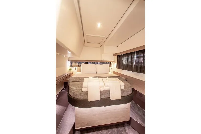 Bodhi Quest Yacht Photos Pics Luxurious cabin interior of 2023 Fountaine Pajot Isla 40 catamaran, featuring a cozy bed and modern design.