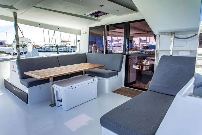 Bodhi Quest Yacht Photos Pics 2023 Fountaine Pajot Isla 40 yacht interior with modern seating and wooden table.