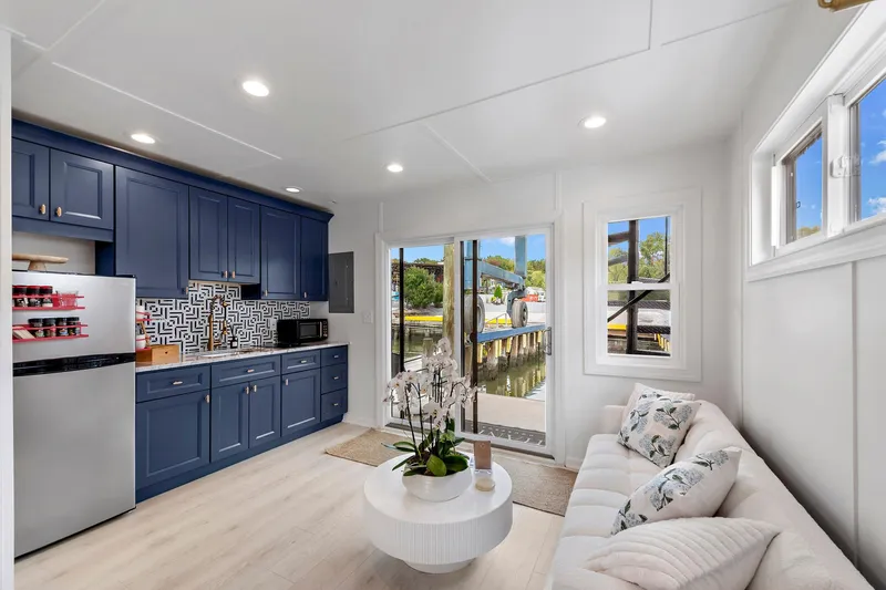  Yacht Photos Pics Modern interior of 2026 Custom Hanks 26 Houseboat with blue kitchen and cozy living area.