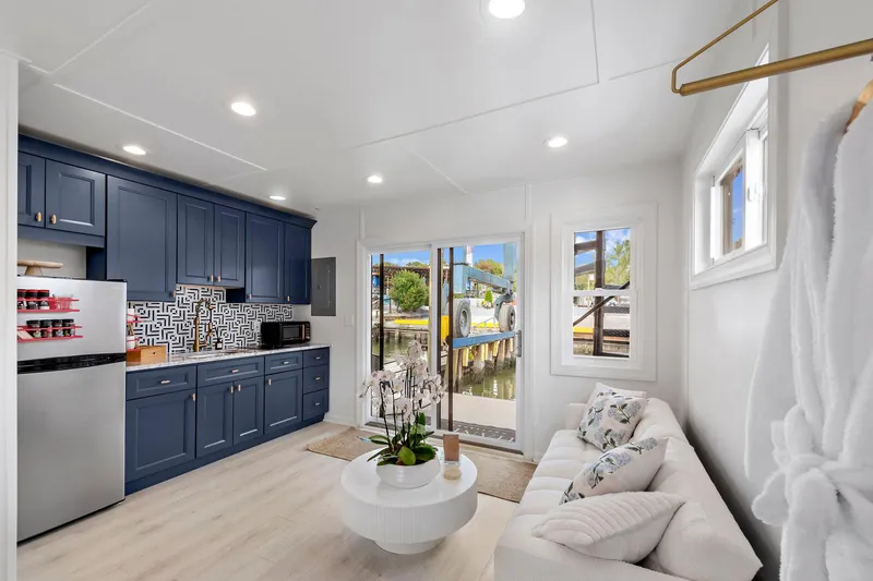  Yacht Photos Pics Modern interior of 2026 Custom Hanks 26 Houseboat with blue cabinets and cozy seating area.