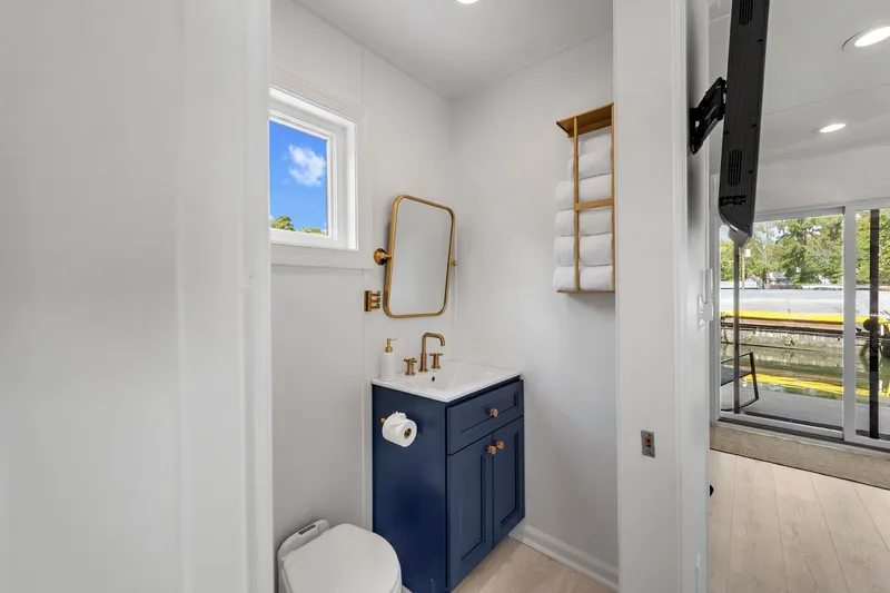  Yacht Photos Pics Modern bathroom in 2026 Custom Hanks 26 Houseboat with blue vanity and gold accents.