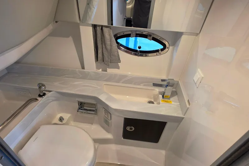  Yacht Photos Pics 2026 Formula 350 Crossover Bowrider I/O bathroom with modern sink, toilet, and porthole window.