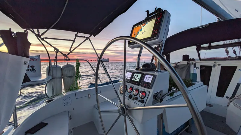  Yacht Photos Pics Cockpit view of a 2004 Catalina 42 MkII sailboat at sunset, featuring navigation equipment.