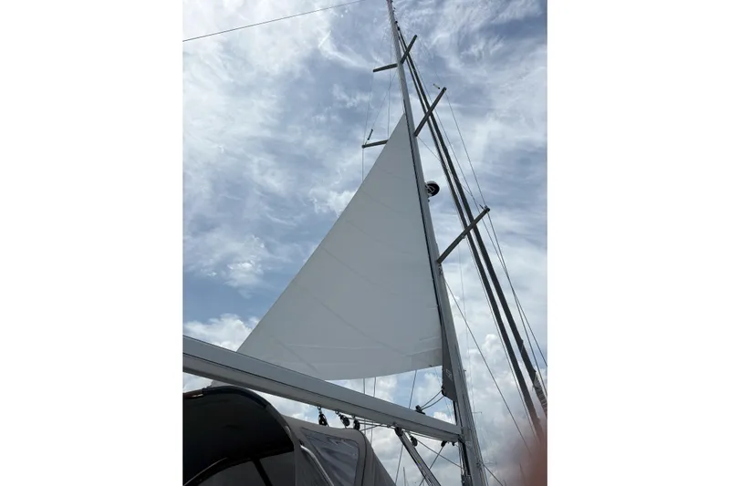 Remedy Yacht Photos Pics Sail of a 2012 Jeanneau 57 yacht against a cloudy sky.