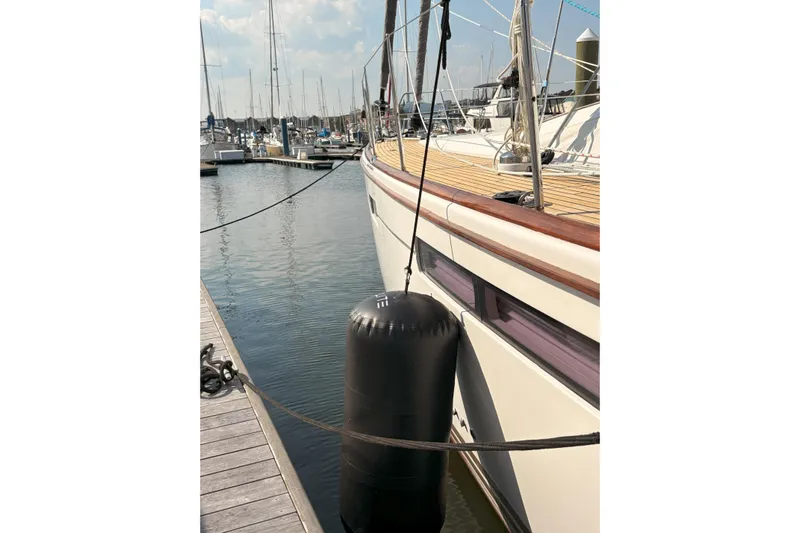 Remedy Yacht Photos Pics 2012 Jeanneau 57 yacht docked with fender, marina background.