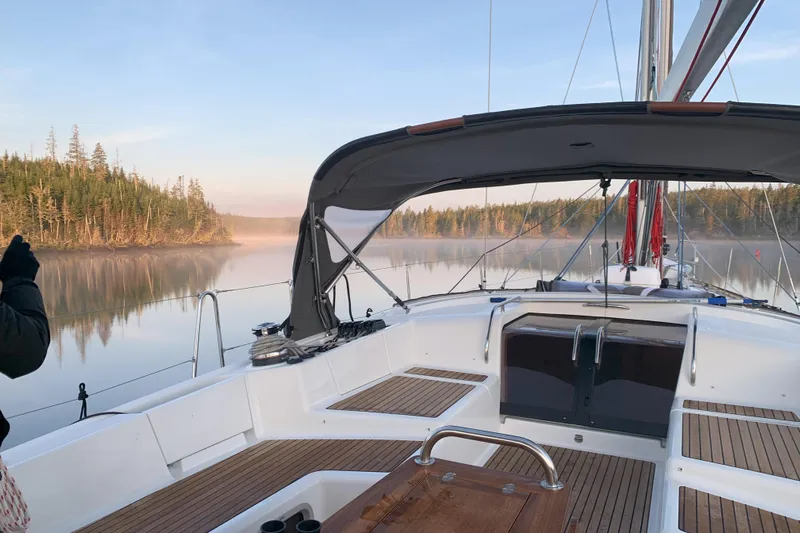 Remedy Yacht Photos Pics Jeanneau 57 sailboat on serene lake with misty forest backdrop, 2012 model.