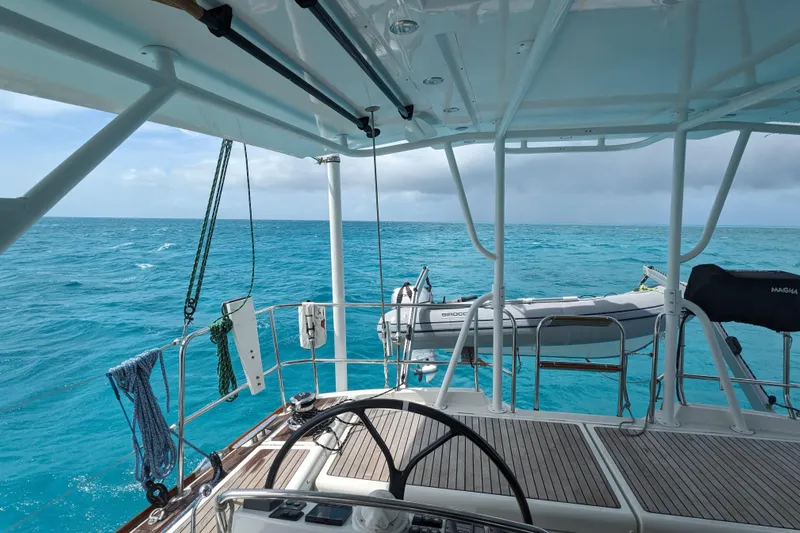 Remedy Yacht Photos Pics Cockpit view from a 2012 Jeanneau 57 yacht overlooking turquoise ocean waters.