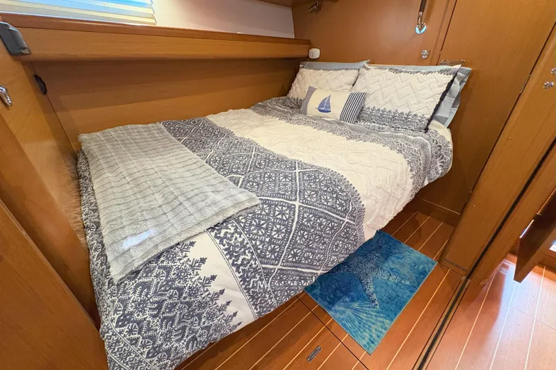 Remedy Yacht Photos Pics Cozy cabin bedroom in a 2012 Jeanneau 57 yacht with nautical-themed bedding.