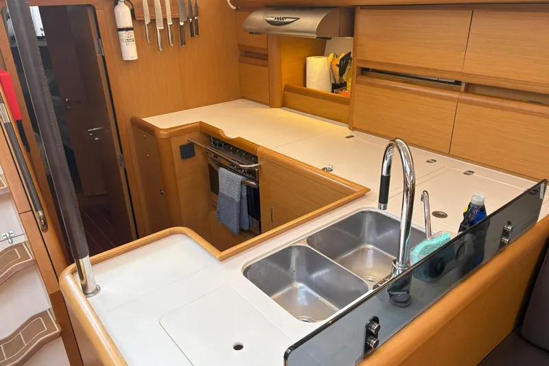 Remedy Yacht Photos Pics Modern kitchen in a 2012 Jeanneau 57 yacht with dual sinks and wooden cabinetry.