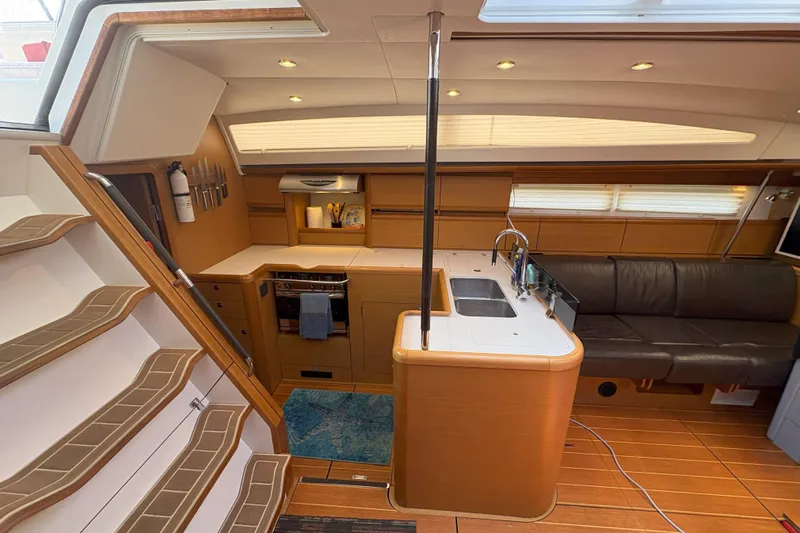 Remedy Yacht Photos Pics Interior of 2012 Jeanneau 57 yacht featuring kitchen, seating, and wooden flooring.