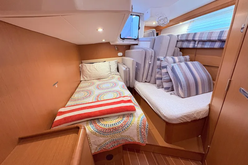 Remedy Yacht Photos Pics Cozy cabin interior of 2012 Jeanneau 57 yacht with colorful bedding and cushions.