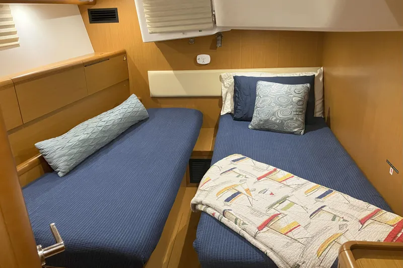 Remedy Yacht Photos Pics Cozy cabin interior of 2012 Jeanneau 57 yacht with twin beds and nautical decor.