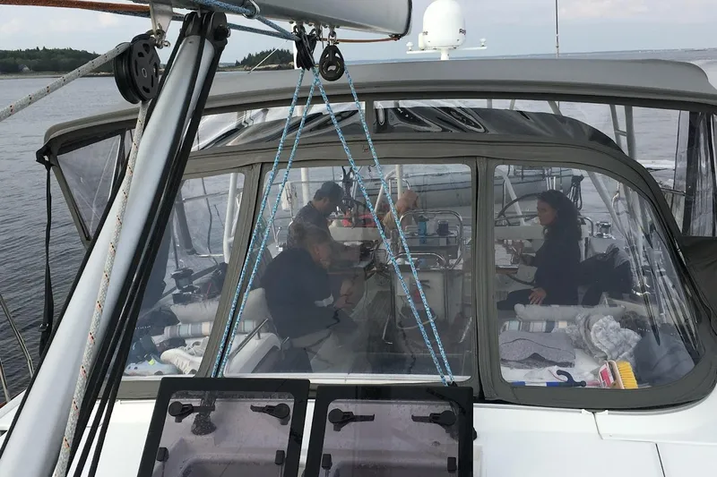 Remedy Yacht Photos Pics People relaxing inside a 2012 Jeanneau 57 sailboat cockpit on calm waters.