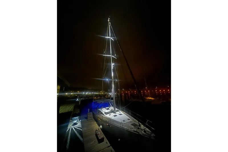 Remedy Yacht Photos Pics Sailboat Jeanneau 57, 2012 model, illuminated at night in a marina setting.