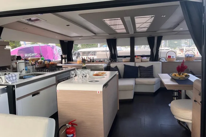 Endless Summer Yacht Photos Pics Luxurious interior of 2022 Fountaine Pajot Aura 51 Catamaran with modern kitchen and seating area.