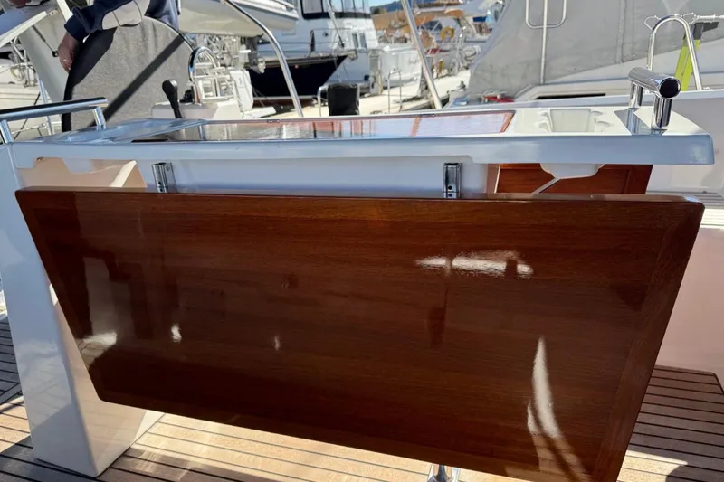 At Last Yacht Photos Pics 2023 Beneteau Oceanis 38.1 yacht cockpit with wooden table and sleek design.