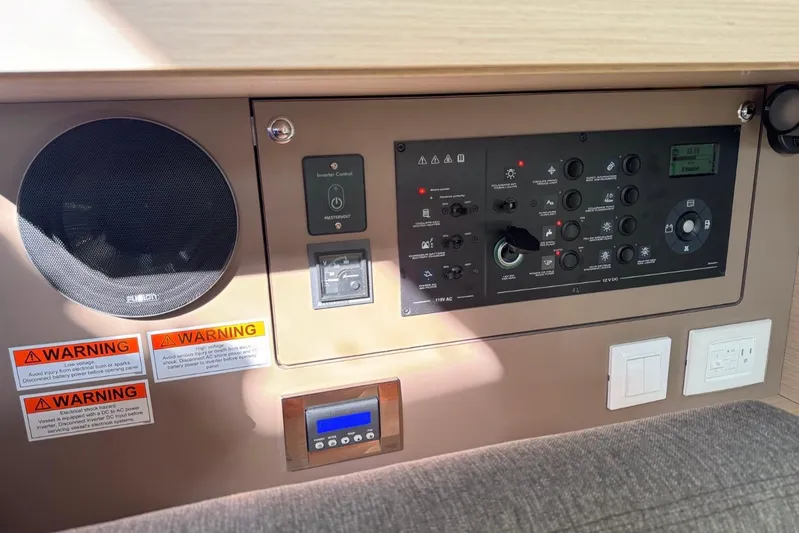 At Last Yacht Photos Pics Control panel of 2023 Beneteau Oceanis 38.1 yacht with warning labels and switches.