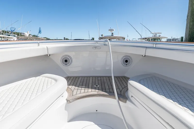  Yacht Photos Pics 2023 Valhalla Boatworks V-46 interior with white seating and wooden deck, docked under clear sky.