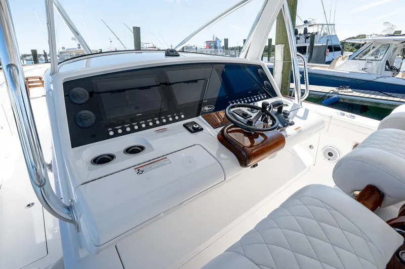  Yacht Photos Pics 2023 Valhalla Boatworks V-46 helm with modern controls and luxurious seating at a marina.