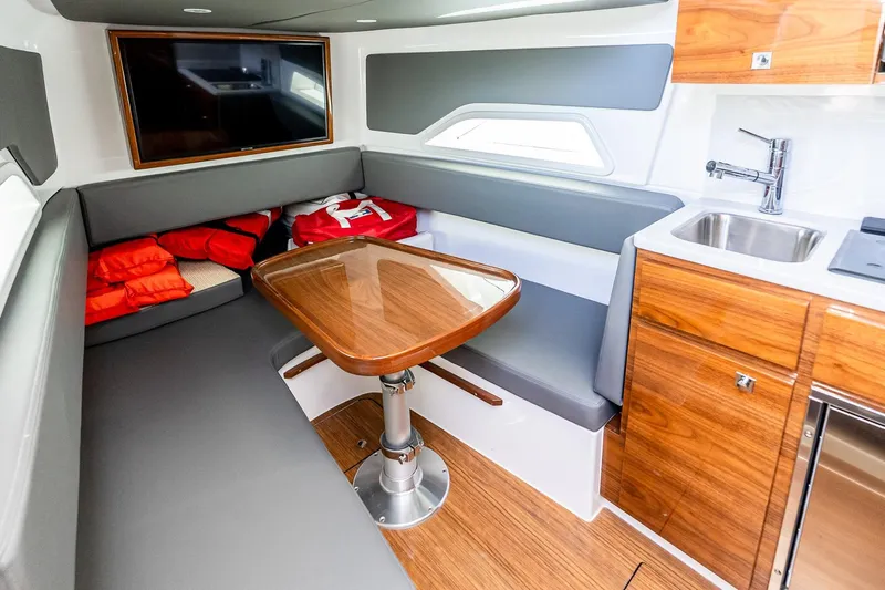  Yacht Photos Pics 2023 Valhalla Boatworks V-46 interior with seating, table, and kitchenette.