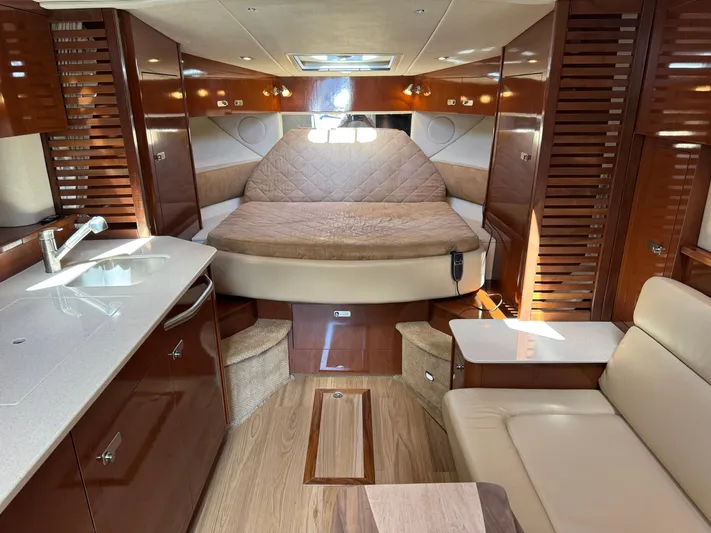  Yacht Photos Pics Luxurious interior of 2010 Sea Ray 370 Sundancer yacht with bed, kitchenette, and seating area.