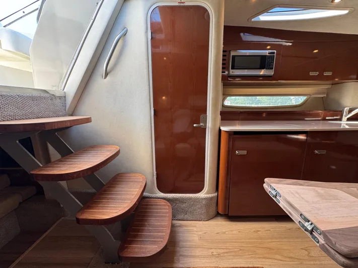  Yacht Photos Pics Interior of 2010 Sea Ray 370 Sundancer yacht with wooden stairs and kitchenette.