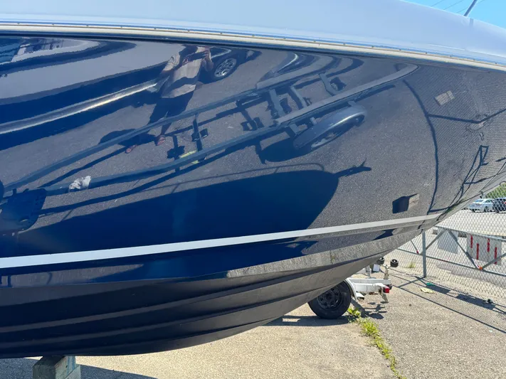  Yacht Photos Pics 2010 Sea Ray 370 Sundancer boat hull reflecting surroundings in a marina setting.