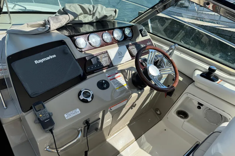  Yacht Photos Pics Cockpit of 2010 Sea Ray 370 Sundancer with Raymarine navigation system and wooden steering wheel.