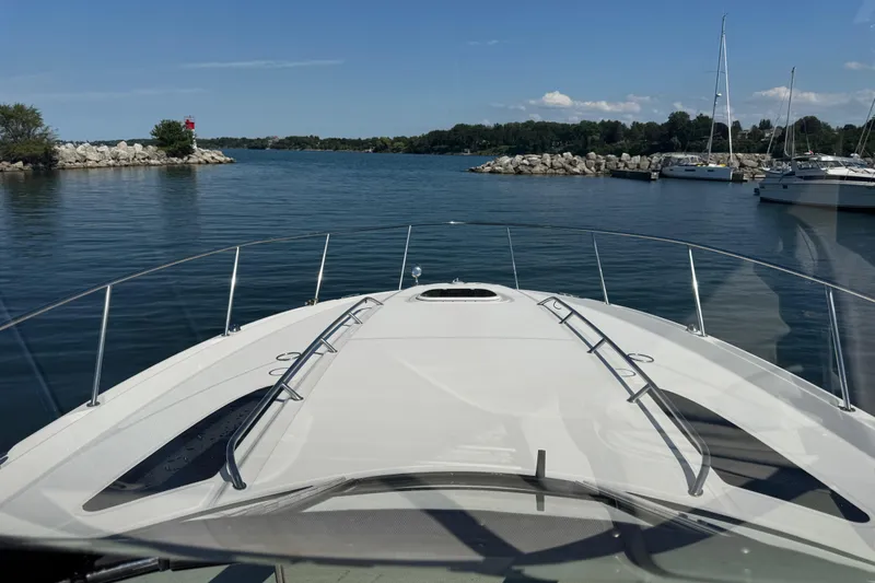  Yacht Photos Pics 2010 Sea Ray 370 Sundancer cruising in a serene marina with clear blue skies.
